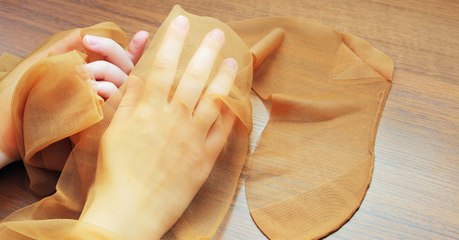 Sie sprüht etwas auf einen Nylonstrumpf. Danach glänzen ihre Fensterscheiben wie neu