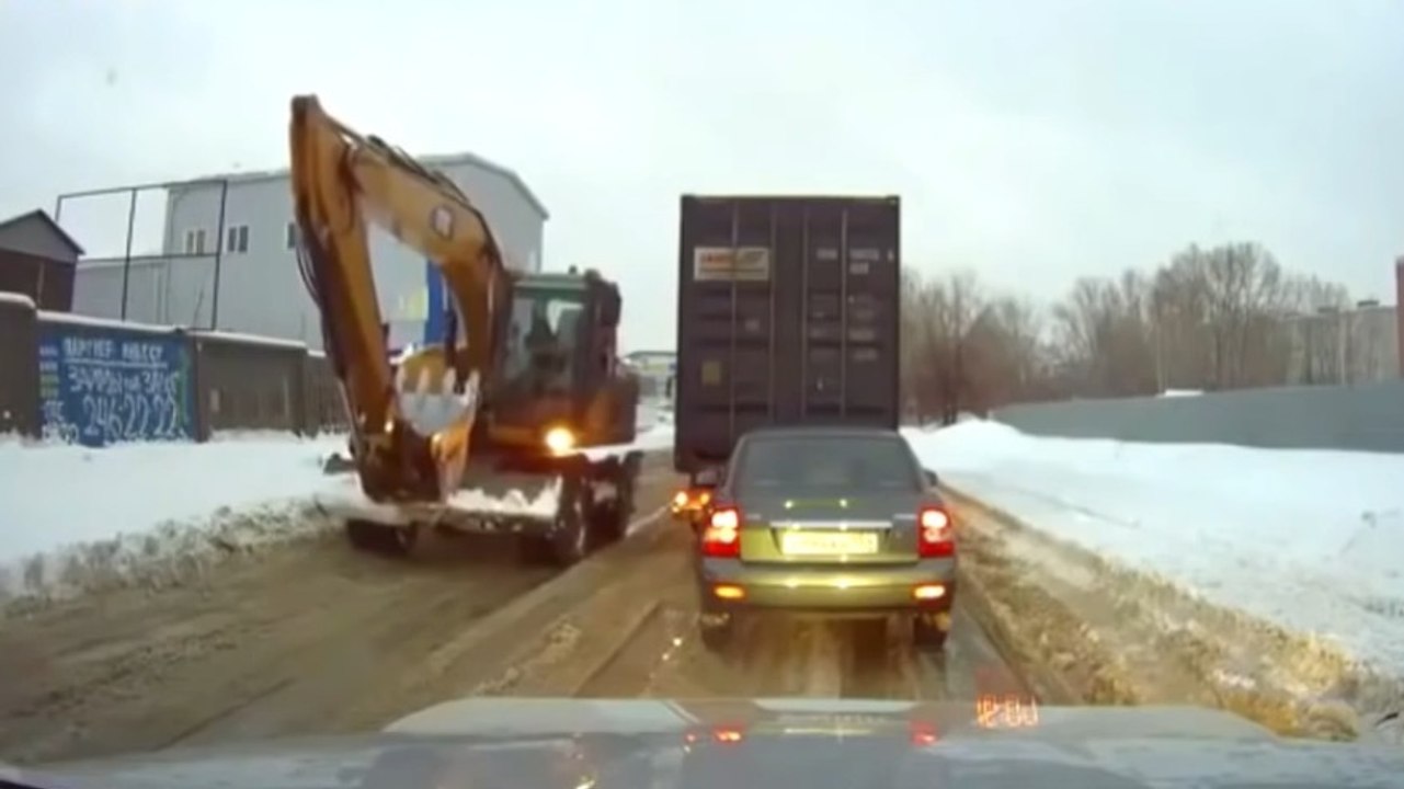 Baggerfahrer hilft einem LKW aus dem Schnee