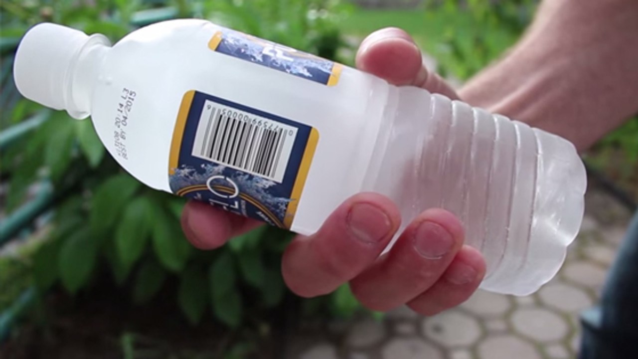 Er hält eine Flasche mit flüssigem Wasser in der Hand. Mit einem Trick gefriert es binnen Sekunden zu Eis!