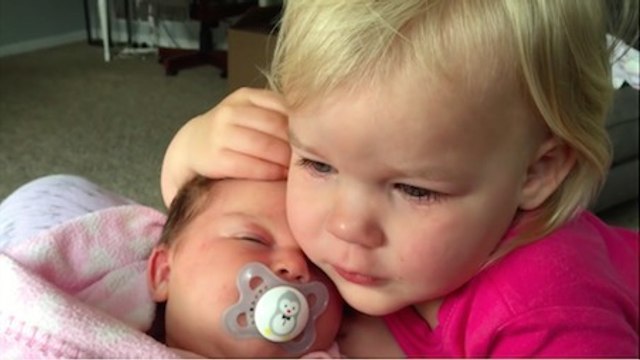Une petite fille se console en prenant sa petite soeur dans ses bras. C'est tellement adorable !