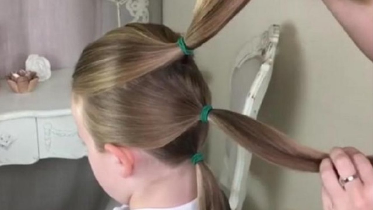 Cette maman commence par faire trois queue de cheval à sa fille... Le résultat est magnifique !