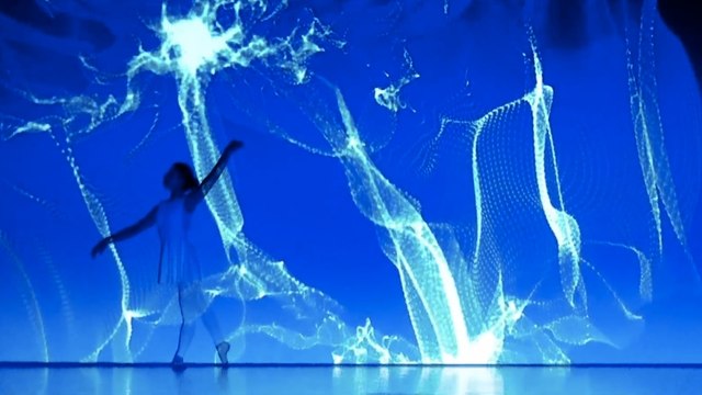 Deux danseuses exécutent une impressionnante chorégraphie avec des projections lumineuses