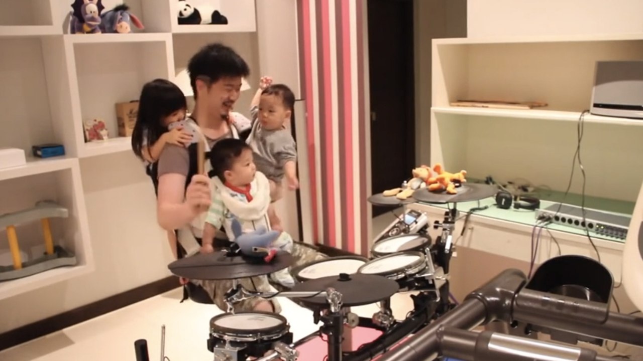 Un papa joue de la batterie avec ses trois bébés