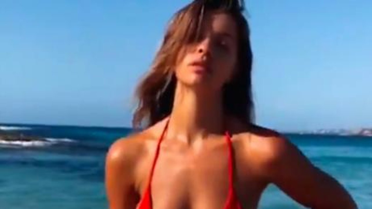 Sie posiert im bikini am strand, aber jemand stiehlt ihr die aufmerksamkeit