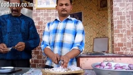 Cet homme coupe les oignons avec une rapidité déconcertante. Regardez, c'est impressionnant