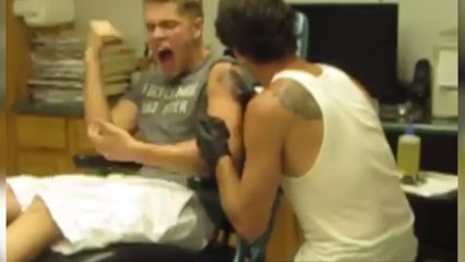 Ce jeune homme est en train de se faire tatouer. Mais il ne se doutait pas que cela serait aussi douloureux