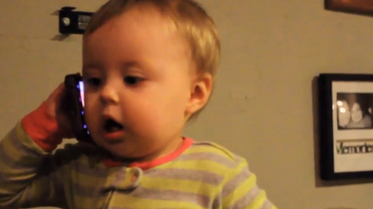 Ce bébé a très envie de parler à son père. Il ne veut pas lâcher le téléphone !