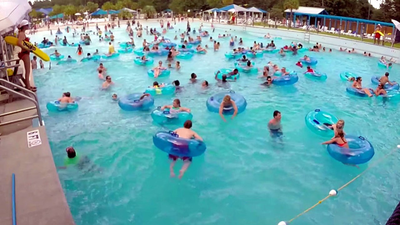 Une maître-nageuse sauve un enfant de la noyade dans une piscine à vagues bondée