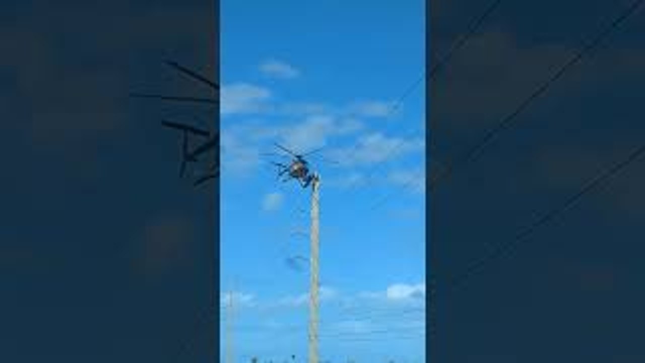 Linesman Balancing on Helicopter for Work