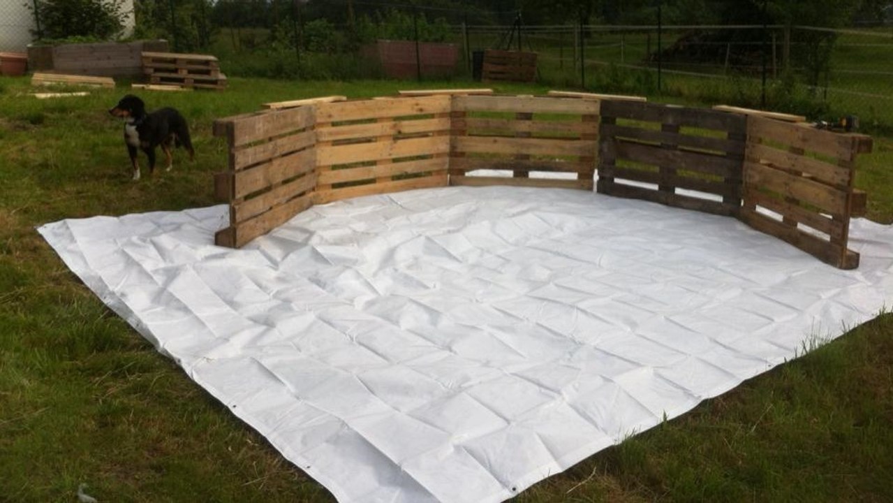 Un homme construit sa piscine avec de simples palettes en bois