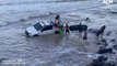 Bystanders work to free a submerged ute off Rainbow Beach, Queensland | January 2022 | ACM