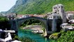People passing over and standing under Old Bridge in Mostar
