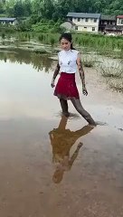 Une fille cherche désespérément quelque chose dans la boue !