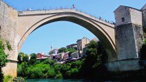 A bridge diver is sitting on metal fence at Old Bridge in Mostar, Bosnia and Herzegovina.