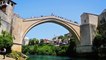 A bridge diver is sitting on metal fence at Old Bridge in Mostar