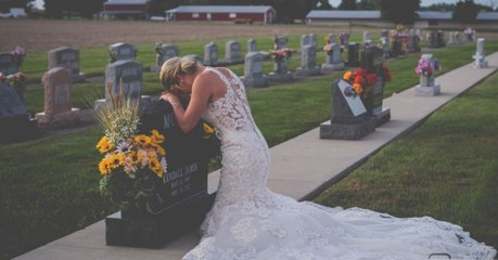 Braut kniet am Tag ihrer Hochzeit vorm Grabstein ihres Bräutigams