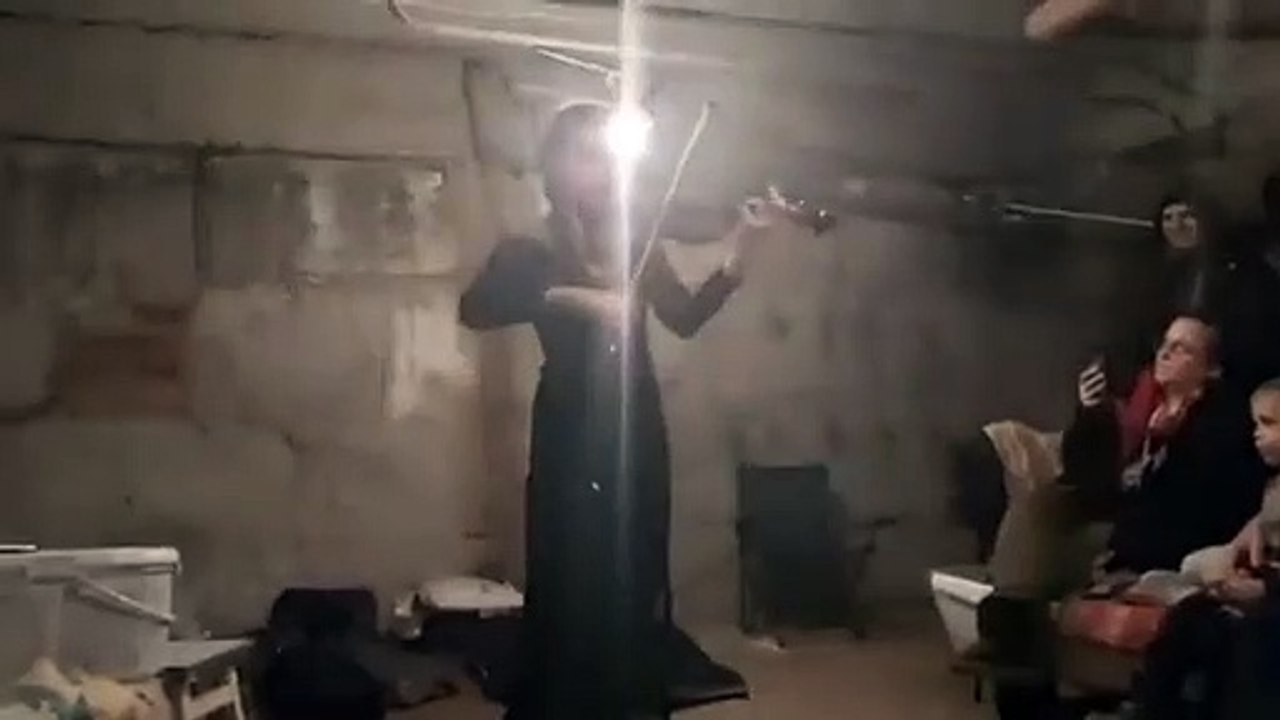 Une violoniste joue du violon dans les sous sols de bunker en Ukraine