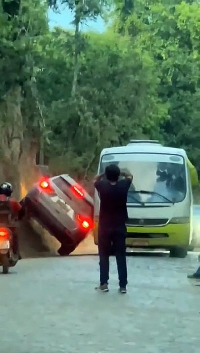 Un automobiliste s'aide de la falaise pour croiser un bus sur une voie étroite !