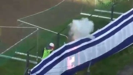 Un fan met le feu au drapeau des supporters adverses en Pologne