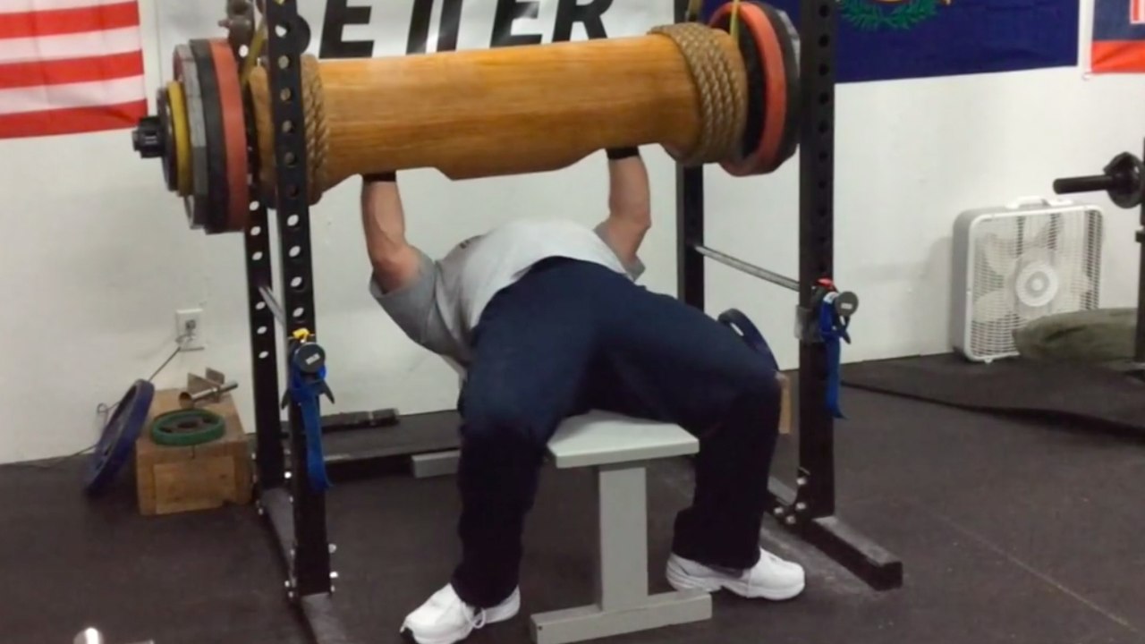 Développé couché: Il soulève un tronc de bois de plus de 210 kilos