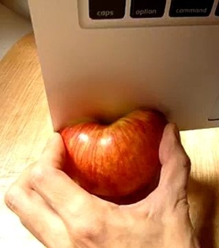 Il coupe une pomme avec son ordinateur