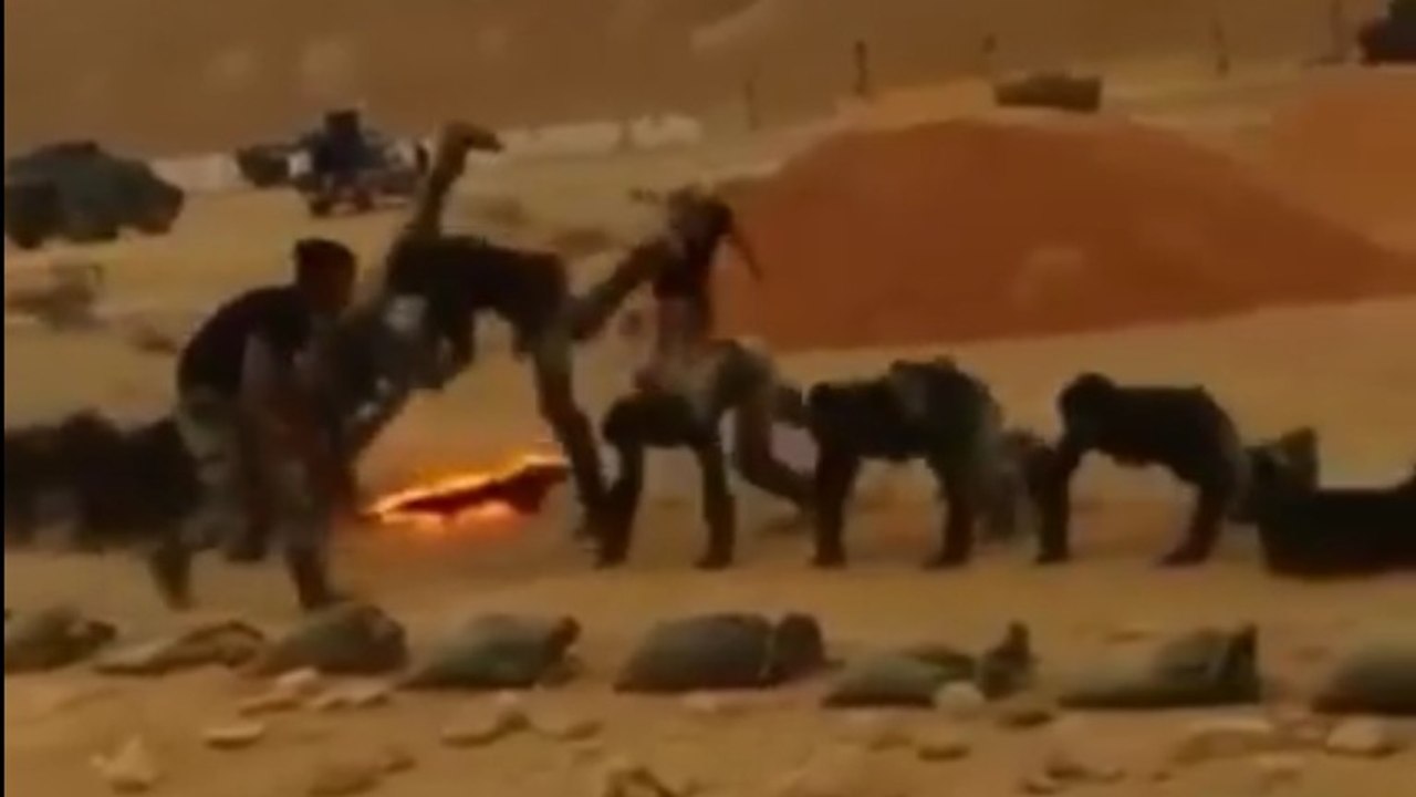 Des militaires font des pompes au-dessus d'un mur de feu