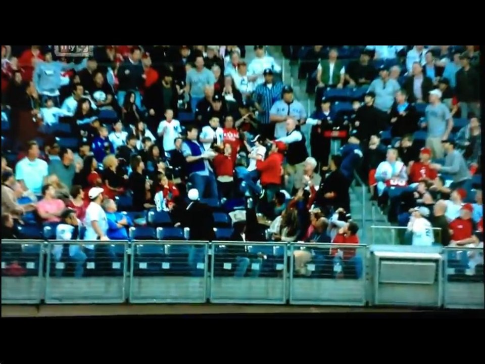 Un enfant attrape une balle de base ball en plein match