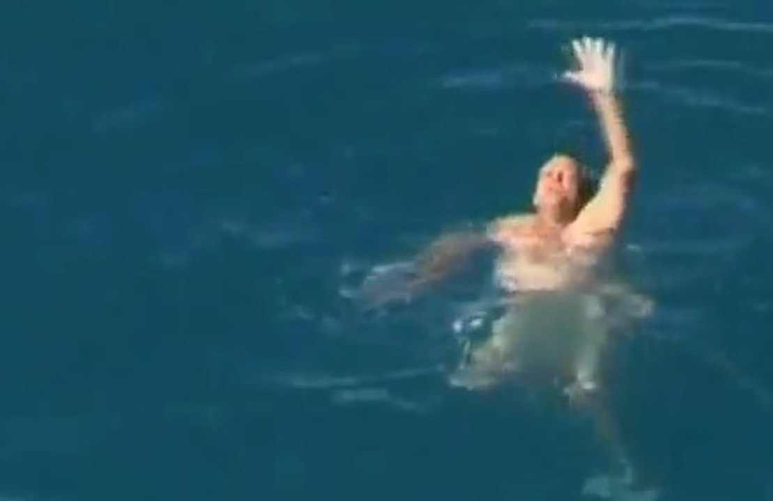 Nu en pleine mer, il se fait encercler par des requins