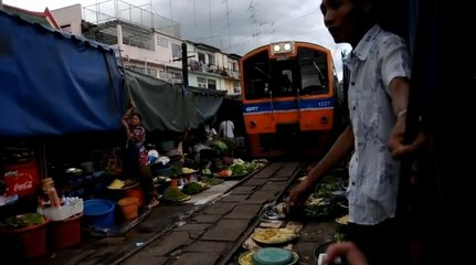 Regardez ce train passer au beau milieu d'un marché en Thaïlande !