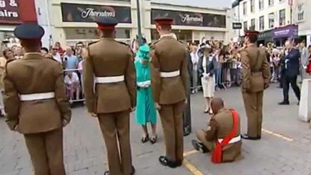 Un soldat s'assoit devant la reine d'Angleterre en pleine cérémonie