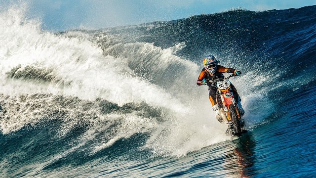 Robbie Maddison roule sur un surfeur avec sa moto aquatique