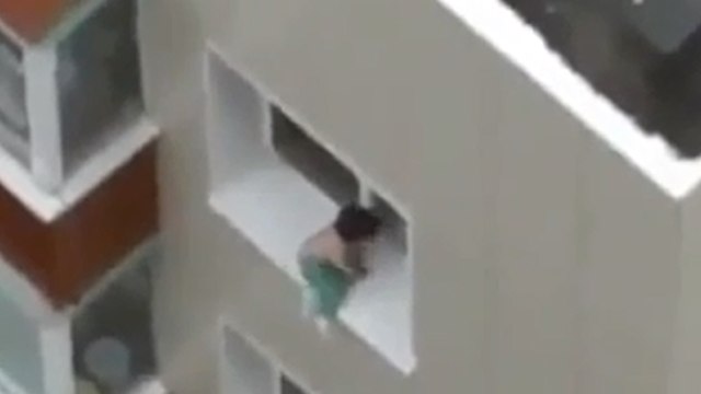 Laissé sans surveillance, cet enfant monte sur le rebord de la fenêtre au dernier étage d'un immeuble