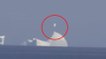 Un homme filme un morceau d'iceberg qui flotte dans l'air