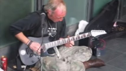 Un sans-abri joue de la guitare électrique à Paris