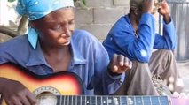 Cette femme Africaine joue de la guitare... à sa manière