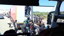 Des migrants prennent d'assaut un camion pour passer la frontière à Calais