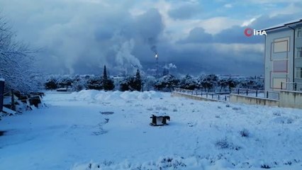 Bembeyaz kar yağışı altında, simsiyah TÜPRAŞ dumanı
