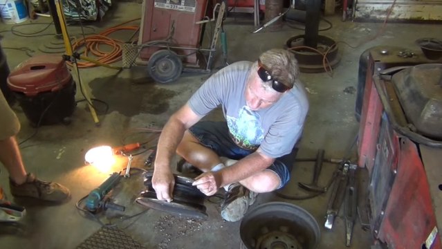 Il fabrique un barbecue avec deux anciennes roues de voiture