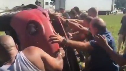 Il fait un tonneau en décapotable et 15 hommes l'aident à sortir de sa voiture