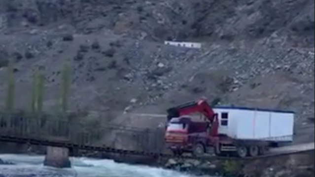 Une énorme camion tente de traverser un petit pont en bois