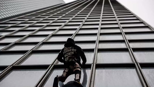 Le Spiderman français Alain Robert, escalade la tour Total à mains nues pour soutenir la grève