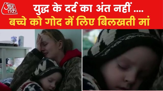 Ukrainian woman weeping in fear carrying her baby in arms