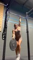 Woman Single Handedly Flips Weight Plate While Doing Pull ups With Other Hand