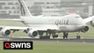 Hair-raising moment Qatar Airways jet navigates bumpy landing with its wheels lifting right off the tarmac