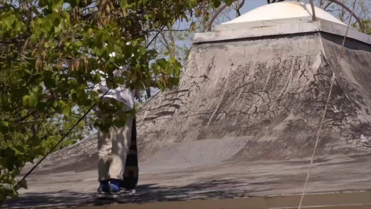Kid on skateboard rides off roof and lands in a center split