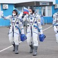 Des cosmonautes embarquent dans l'ISS avec une combinaison jaune et bleue carré