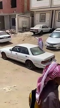 معلّم ينظم حركة السير أمام مدرسة بمكة لحماية الطلاب من حوادث الدهس