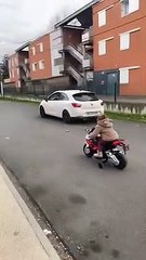 Kid on Toy Motorbike Challenges Driver to a Race