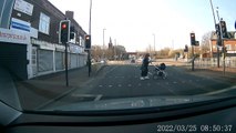 Shocking dashcam footage of a car driving through a red light at speed and nearly hitting a mum a child crossing the road