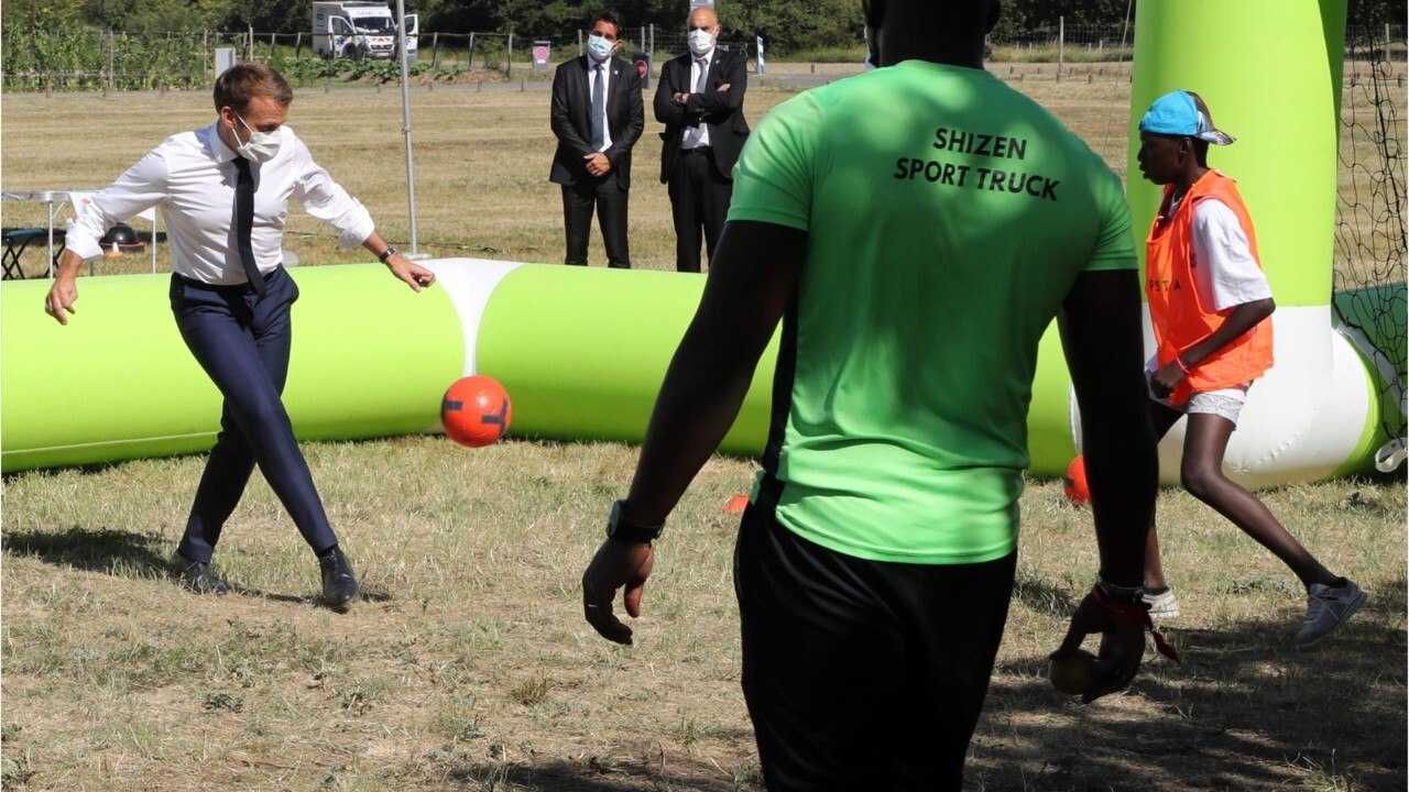 FEMME ACTUELLE - Emmanuel Macron se lance dans match de football avec des jeunes, masqué et en costume-cravate
